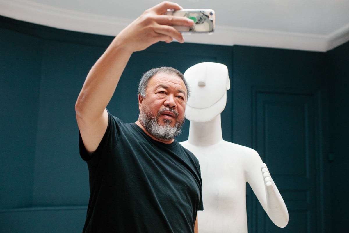 Ai Weiwei takes a selfie with one of his sculptures at his Greek museum debut. Photo: Museum of Cycladic Art via Facebook
