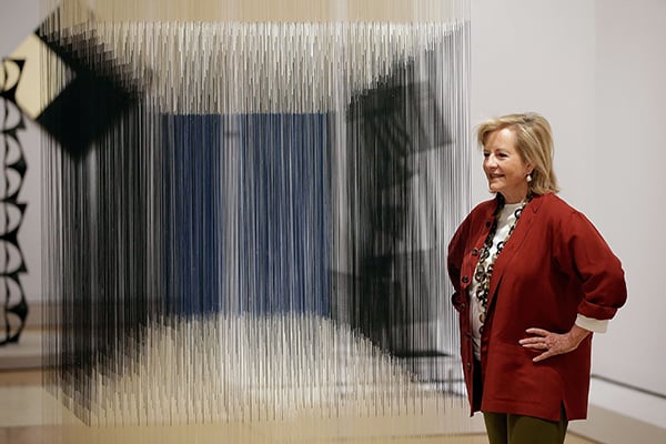 Patricia Phelps de Cisneros poses with the artwork <em>Nylon Cube</em> by Venezuelan artist Jesus Soto, part of the exhibition "Radical Geometry: Modern Art of South America from the Patricia Phelps de Cisneros Collection" at the Royal Academy of Arts in London, England. Courtesy of photographer Matthew Lloyd/Getty Images.