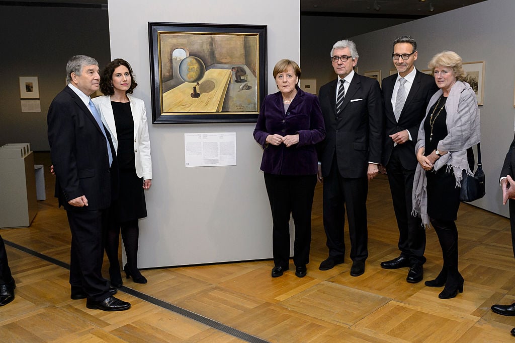 Avner Shalev, Rosenberg, Chancellor Angela Merkel, Walter Smerling, Alexander Koch and Prof. Monika Grütters attend a preview prior to the opening of the exhibition " Art from the Holocaust " at the German Historical Museum on January 25, 2016 in Berlin, Germany. "The Art of the Holocaust" features works created by concentration camp prisoners between 1939 and 1945. Courtesy of Michael Ukas - Pool / Getty Images.