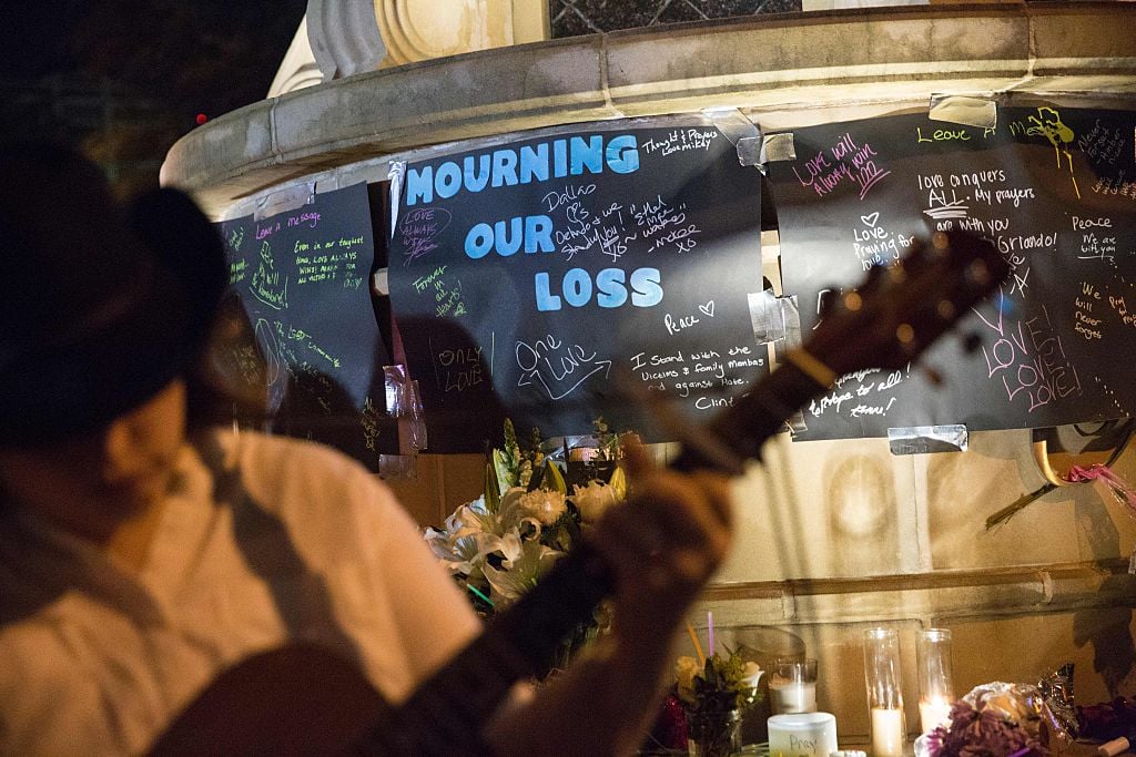 A musician sings and plays guitar during a vigil at the Legacy of Love statue in Dallas, Texas, on June 12, 2016, for victims of the attack at Orlando's Pulse Nightclub in Orlando, Florida. Fifty people died when a gunman allegedly inspired by the Islamic State group opened fire inside a gay nightclub in Florida, in the worst terror attack on US soil since September 11, 2001. / AFP / Laura Buckman (Photo credit should read LAURA BUCKMAN/AFP/Getty Images)