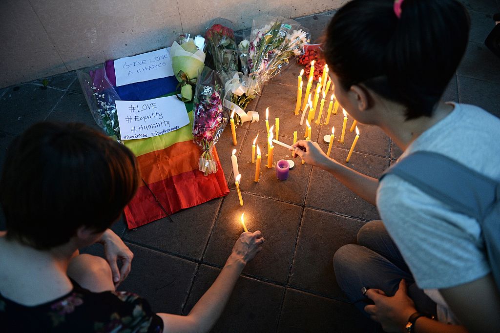 Members of the LGBT community light candles by the US Embassy in Bangkok on June 13, 2016 during a vigil for victims after a gunman opened fire in a gay nightclub in Orlando, Florida in the worst mass shooting in modern US history. US anti-terror strategy came under fresh scrutiny after a gunman previously cleared of jihadist ties launched a hate-fueled rampage in a Florida gay club that left 50 people dead. / AFP / LILLIAN SUWANRUMPHA (Photo credit should read LILLIAN SUWANRUMPHA/AFP/Getty Images)
