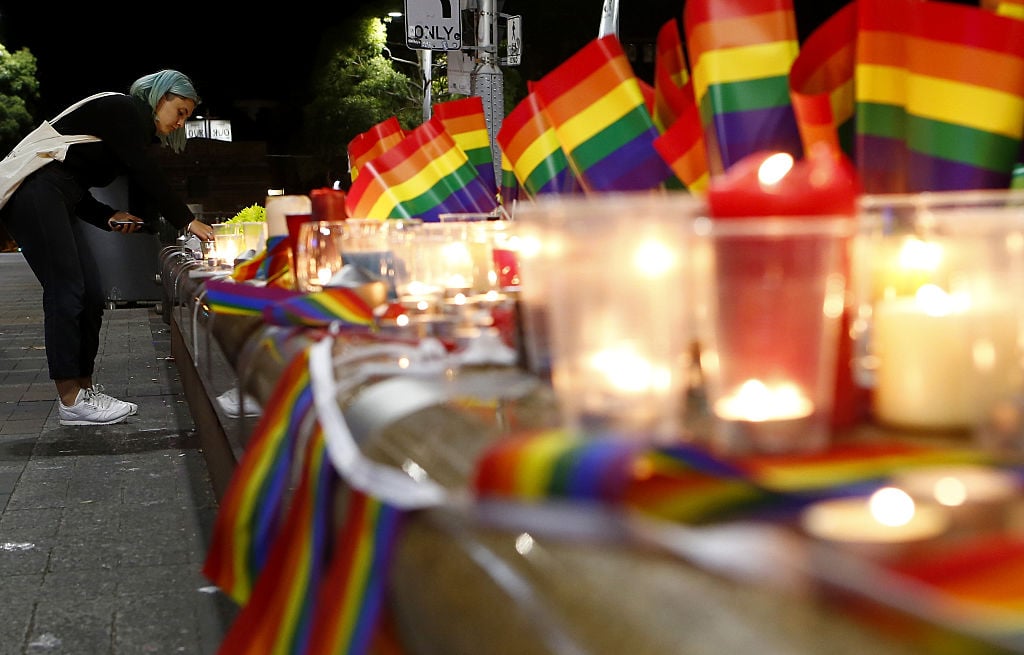 A woman lights a candle during a candlelight vigil for the victims of the Pulse Nightclub shooting in Orlando, Florida, at Oxford St on June 13, 2016 in Sydney, Australia. 50 people were killed and 53 injured after a gunman opened fire on people in a gay nightclub in Florida. It is the deadliest mass shooting in US history. Photo by Daniel Munoz/Getty Images.