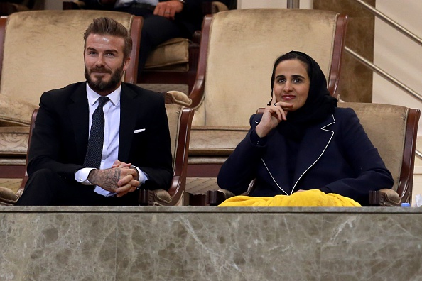 Sheikha Al-Mayassa bint Hamad bin Khalifa Al-Thani (right), with David Beckham at a tennis match in Doha, Qatar on February 27, 2015. Photo by Mohamed Farag/Anadolu Agency/Getty Images.
