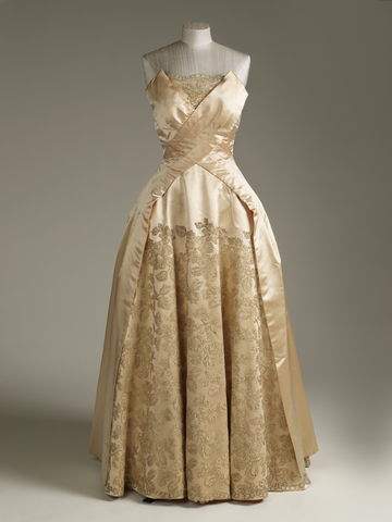 Queen Elizabeth II's cream silk chiffon dress with draped cape, graduated to the back. Richly embroidered with iridescent sequins in a geometric design. Worn for a Commonwealth Heads of Government reception at Buckingham Palace, 1977. Courtesy of the Royal Collection Trust.