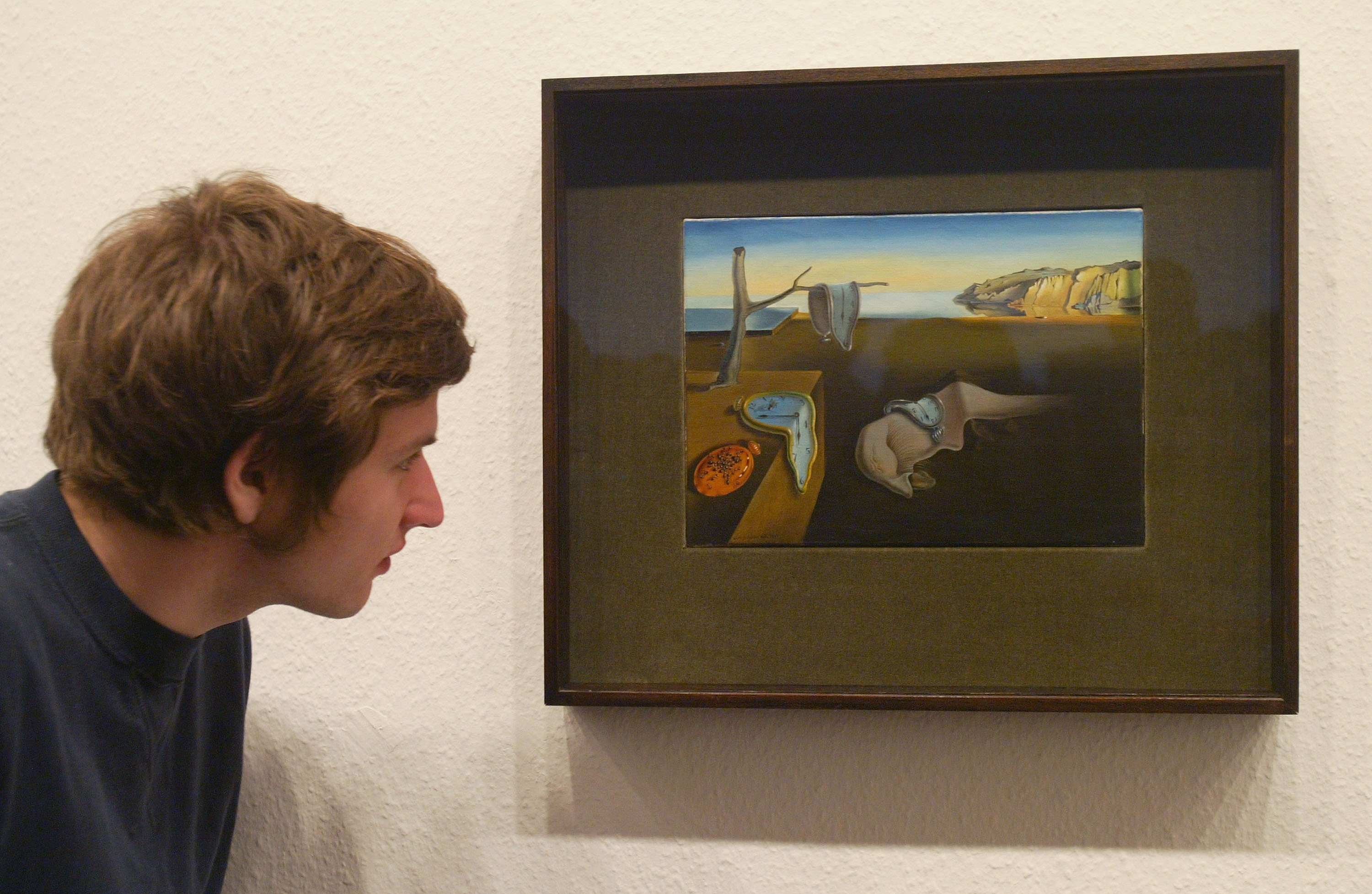A visitor takes a look at Salvador Dali's "The Persistence of Memory" at the MoMA exhibit, on March 24, 2004 in Berlin, Germany. Photo: Sean Gallup/Getty Images.