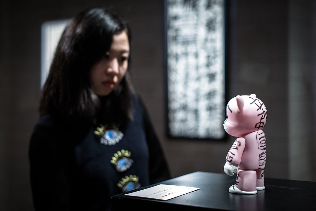 A woman looks at an artwork by Tsang Tsou Choi (also known as "king of Kowloon") during a preview of the exhibition titled " They would be kings" held by the Sotheby's auction house in Hong Kong on March 18, 2016. Courtesy of PHILIPPE LOPEZ/AFP/Getty Images.