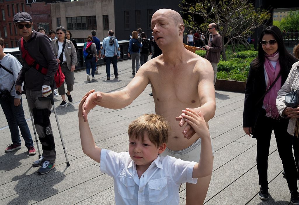 A Tourist holds hands with artist Tony Matelli's "Sleepwalker" (2014), a lifelike figure is of a man in white briefs wandering in his sleep with outstretched arms installed on the Highline as part of the show "Wanderlust" April 25, 2016. Wanderlust is a group exhibition that runs April 21, 2016 March 2017 Various locations on the High Line / AFP / TIMOTHY A. CLARY / RESTRICTED TO EDITORIAL USE - MANDATORY MENTION OF THE ARTIST UPON PUBLICATION - TO ILLUSTRATE THE EVENT AS SPECIFIED IN THE CAPTION (Photo credit should read TIMOTHY A. CLARY/AFP/Getty Images)