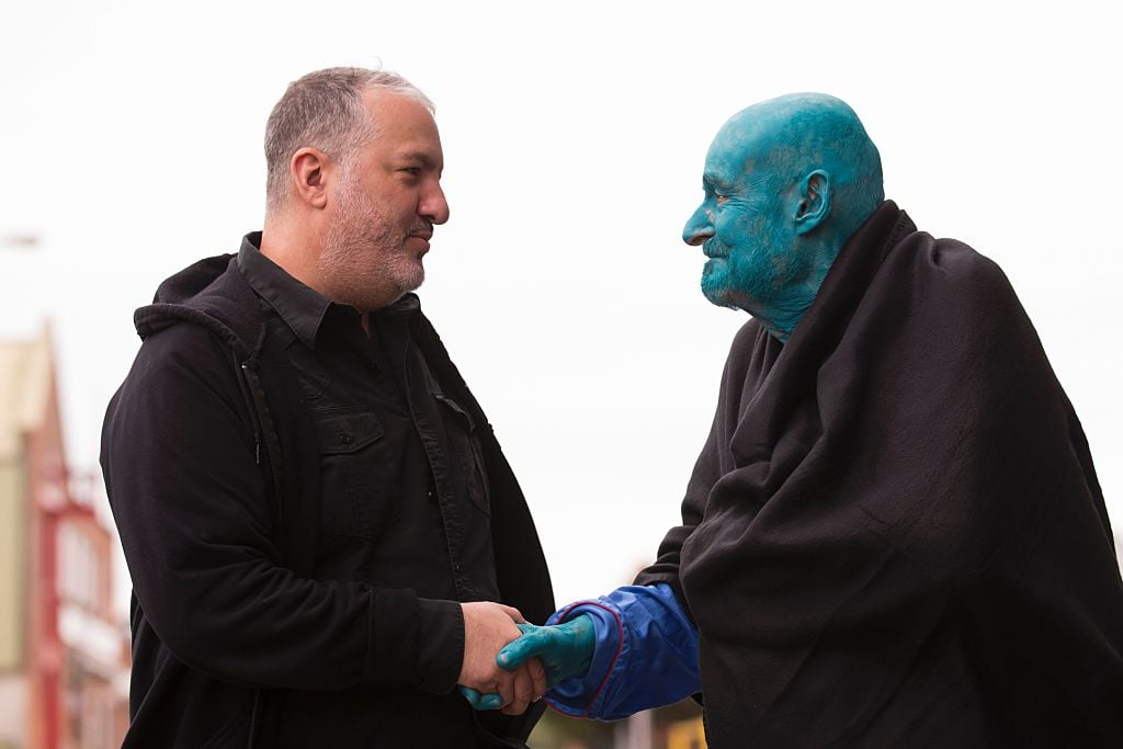 Spencer Tunick shakes hands with 80 year old art collector Stephane Janssen who has participated in 20 of Turnick's installations. Photo by Jon Super/AFP courtesy of Getty Images. 