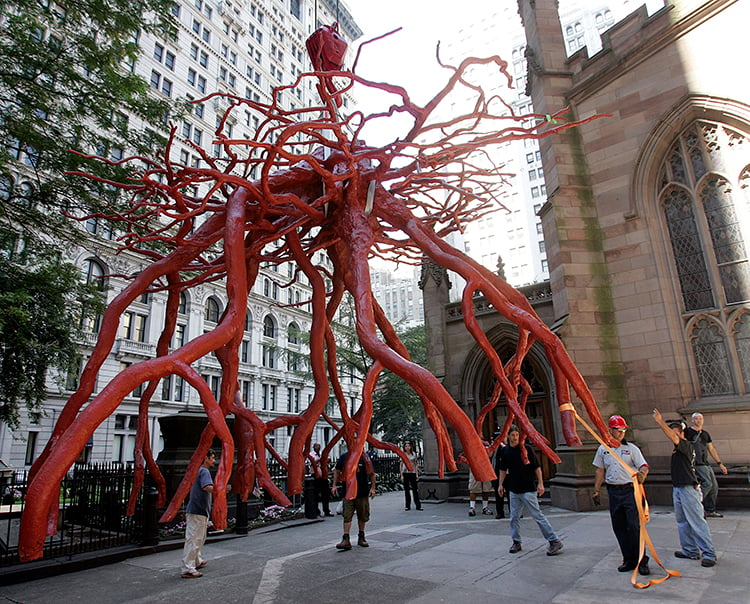 Guided by workmen, Steve Tobin's Trinity Root sculpture is lowered into place by a crane in the Trinity Church yard September 8, 2005 in New York. Courtesy of Stephen Chernin/Getty Images.