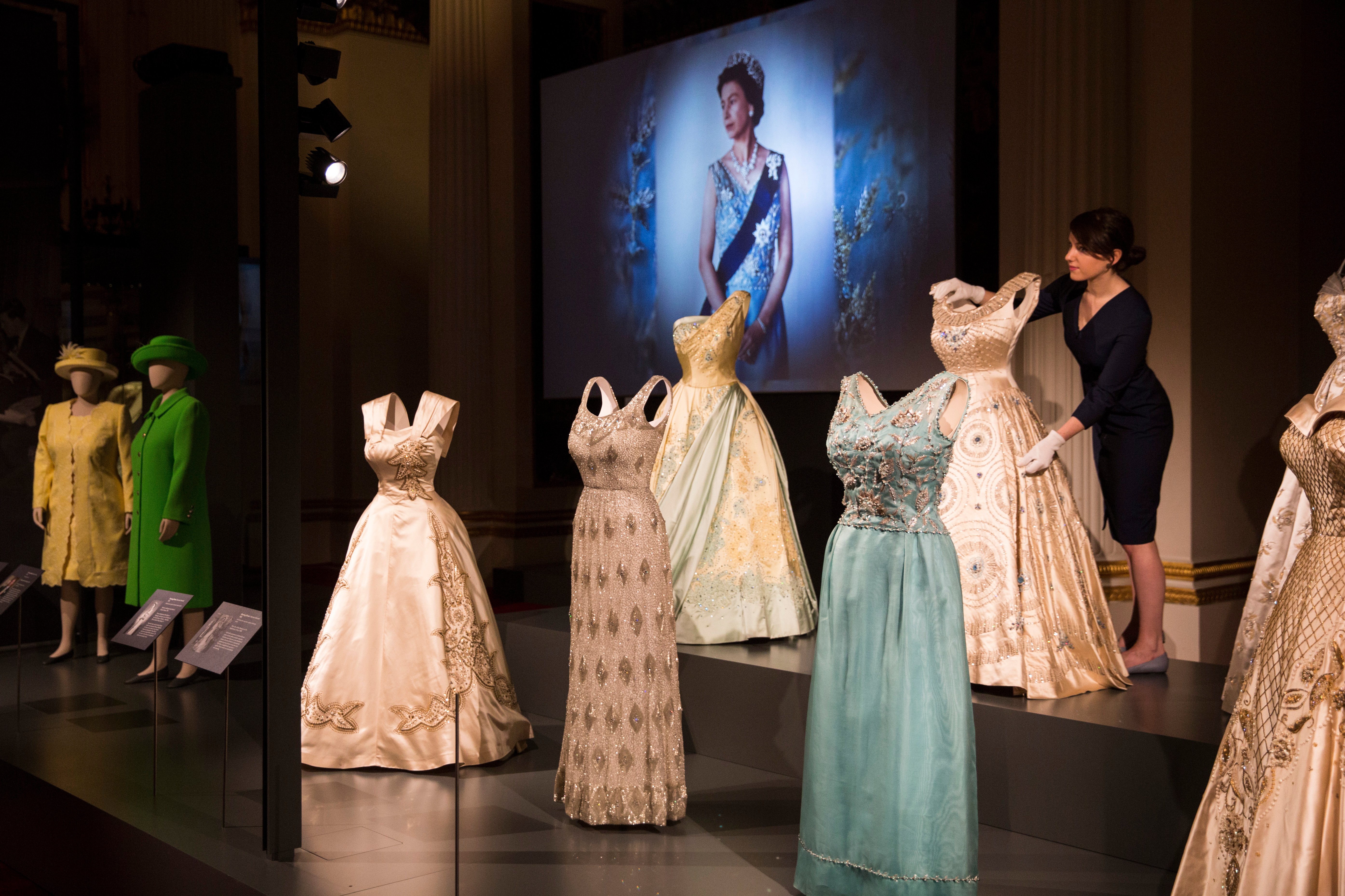 Outfits worn by Queen Elizabeth II are displayed at Buckingham Palace in "Fashioning a Reign: 90 Years of Style From the Queen's Wardrobe." Courtesy of Dan Kitwood/Getty Images.