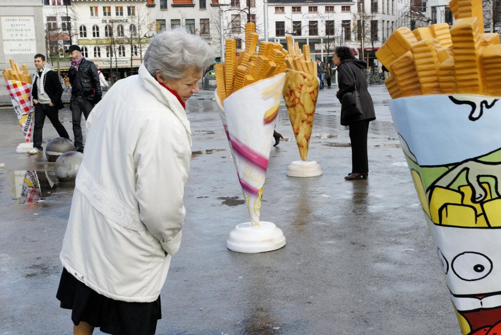 People looking at a 2006 art exhibition of giant French fries during the 'Krak van de Frietzak.' Courtesy of Getty Images.
