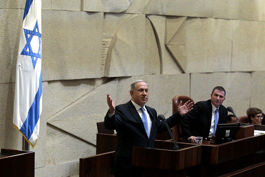 Israeli Prime Minister Benjamin Netanyahu speaks at the Knesset, Israel's Parliament. Karavan's relief is in the background. Photo: JIM HOLLANDER/AFP/Getty Images.