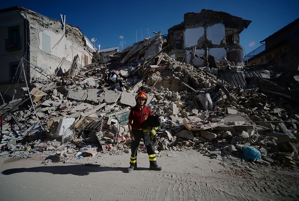 A fireman stands next to ruins in the central destroyed street of Amatrice in central Italy on August 25, 2016 after a strong eartquake that claimed at least 247 lives. Central Italy was struck by a powerful, 6.2-magnitude earthquake in the early hours of August 24, that shook central Italy and the death toll rose to 247 on August 25, as rescuers desperately searched for survivors in the rubble of devastated mountain villages. Hundreds of others were injured, some critically, and an unknown number were trapped under the ruins of collapsed buildings after Wednesday's pre-dawn quake. Photo Filipo Monteforte/AFP/Getty Images.