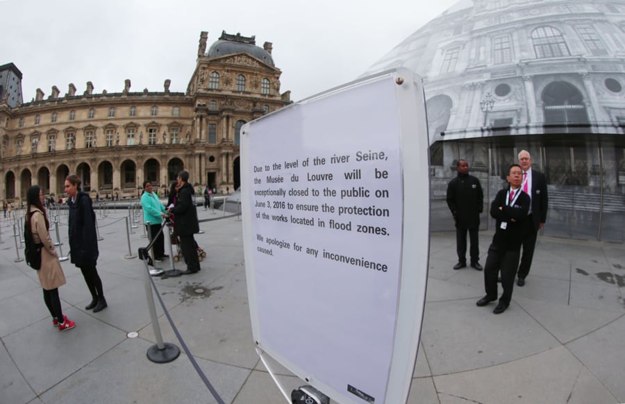 A photo shows a placard announcing the closure of the Louvre Museum on June 3, 2016 in Paris, after the rain-swollen river Seine reached its highest level in three decades, spilling its banks and prompting the museum to shut its doors and evacuate artworks in its basement. Parisians were urged to avoid the banks of the river which was expected to reach a peak of six metres (19 feet) today, while deadly floods continued to wreak havoc elsewhere in France and Germany. / AFP / JOEL SAGET (Photo credit should read JOEL SAGET/AFP/Getty Images)