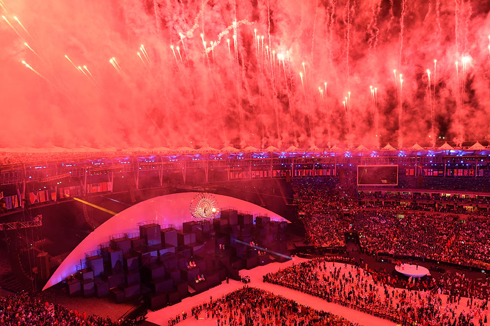 Fiireworks explode over the Maracana stadium after the lighting of the Olympic flame in front of an Anthony Howe sculpture at the Rio 2016 Olympic Games at the Maracana stadium in Rio de Janeiro. Courtesy of Antonin Thuillier/AFP/Getty Images.