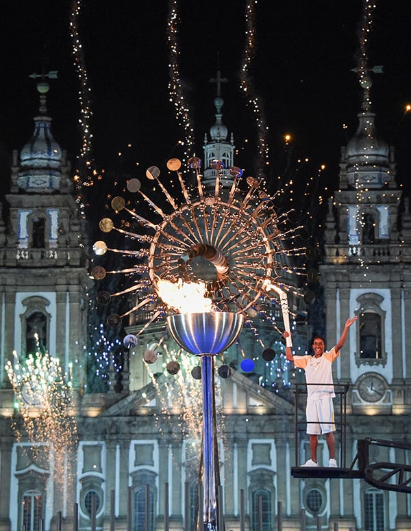 Brazilian teen athlete Jorge Alberto Gomes, 14, lights the cauldron at Candelaria Church with the Olympic torch following the opening ceremony of the Rio 2016 Olympic Games in Rio de Janeiro. Courtesy of Mark Ralston/AFP/Getty Images.