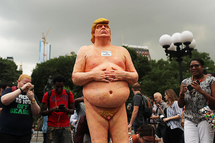 A bystanders looks at an illegally-erected statue of a naked GOP presidential candidate Donald Trump that appeared in San Francisco on August 18, 2016. Courtesy of Justin Sulliva/Getty Images.