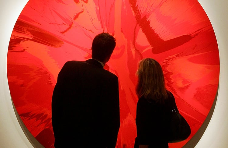 A couple admires Damien Hirst's Beautiful RED Spin Painting on sale at Sotheby's London for Valentine's Day 2008. Courtesy of Cate Gillon/Getty Images.