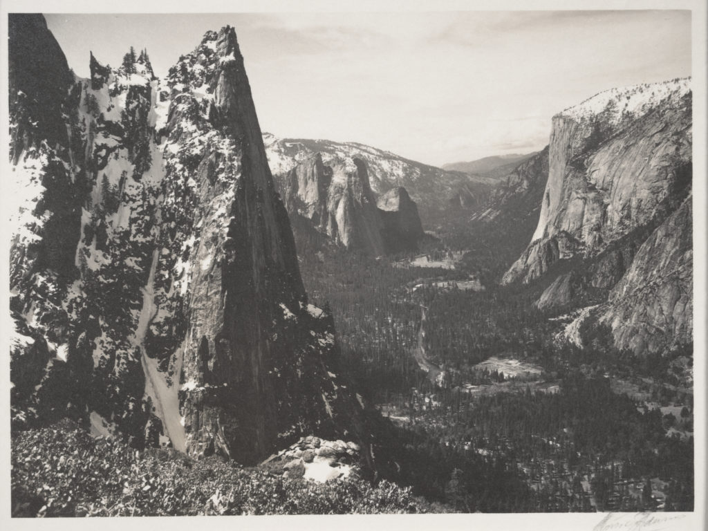 [cliff with narrow triangular face in shadow at left, valley view]