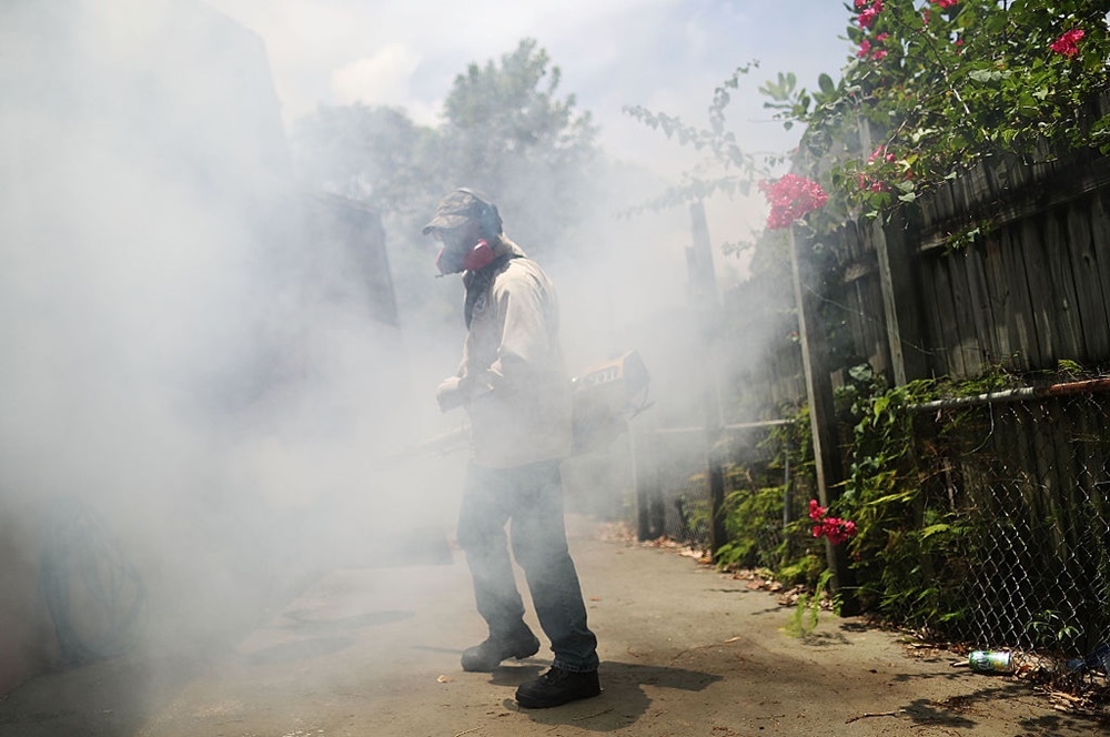 Carlos Varas, a Miami-Dade County mosquito control inspector, sprays pesticide in the Wynwood neighborhood. Photo Joe Raedle/Getty Images.