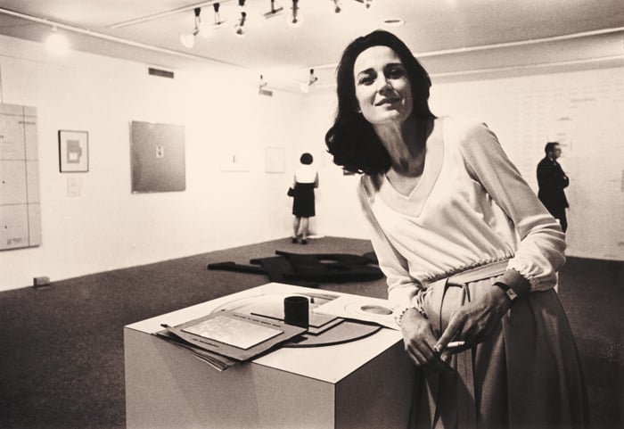 Virginia Dwan standing in the Language III installation. Image courtesy the Dwan archive.