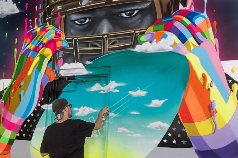 Dasic Fernández creates a mural at the Miami Dolphin's Hard Rock Stadium. Courtesy of Martha Cooper/Goldman Global Arts.