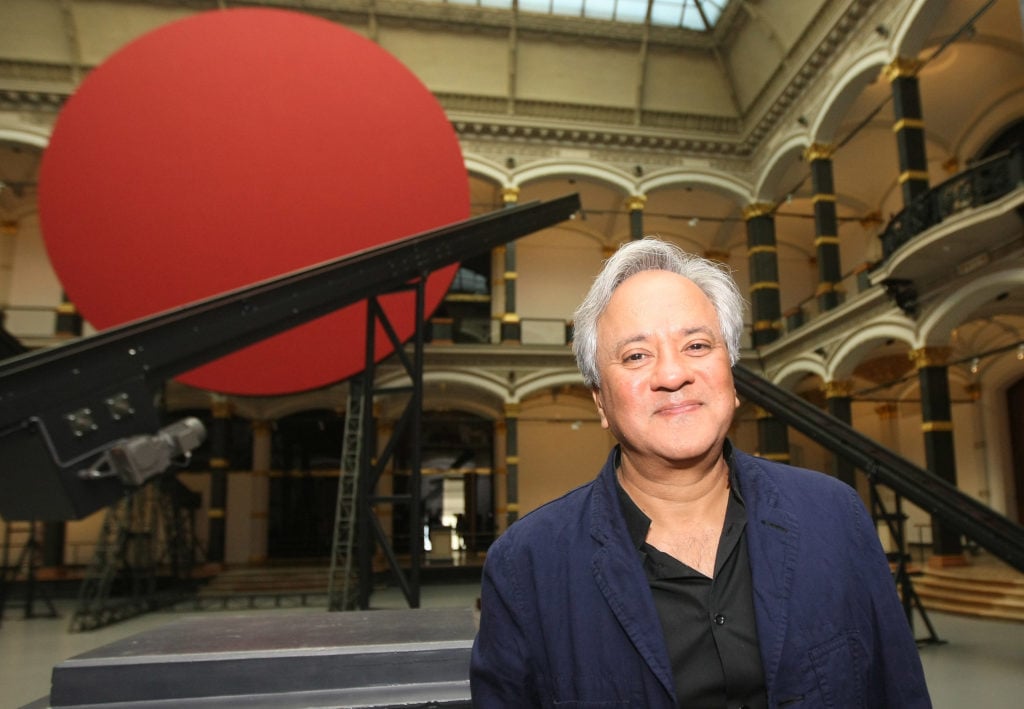 British sculptor Anish Kapoor poses in front of his work prior to the opening of the 