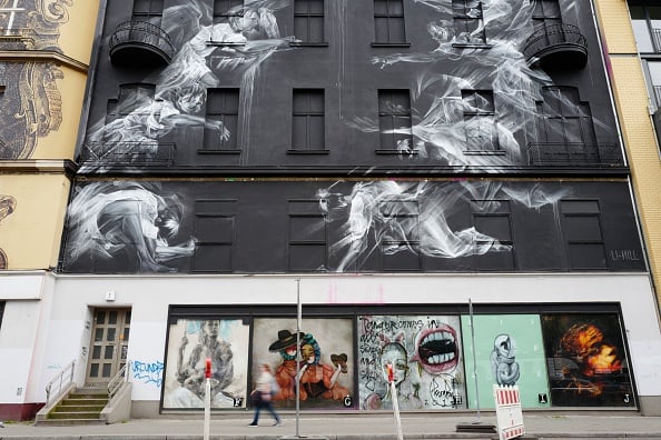 A mural (top) by artist Aaron Li-Hill decorates the building that will house the Urban Nation museum for urban contemporary art, in Berlin on may 20, 2016. The museum, the first of its kind exclusively dedicated to street art, is expected to open its doors in 2017, though many of the works will be displayed where they belong: in the street. / AFP / John MACDOUGALL / RESTRICTED TO EDITORIAL USE - MANDATORY MENTION OF THE ARTIST UPON PUBLICATION - TO ILLUSTRATE THE EVENT AS SPECIFIED IN THE CAPTION (Photo credit should read JOHN MACDOUGALL/AFP/Getty Images)