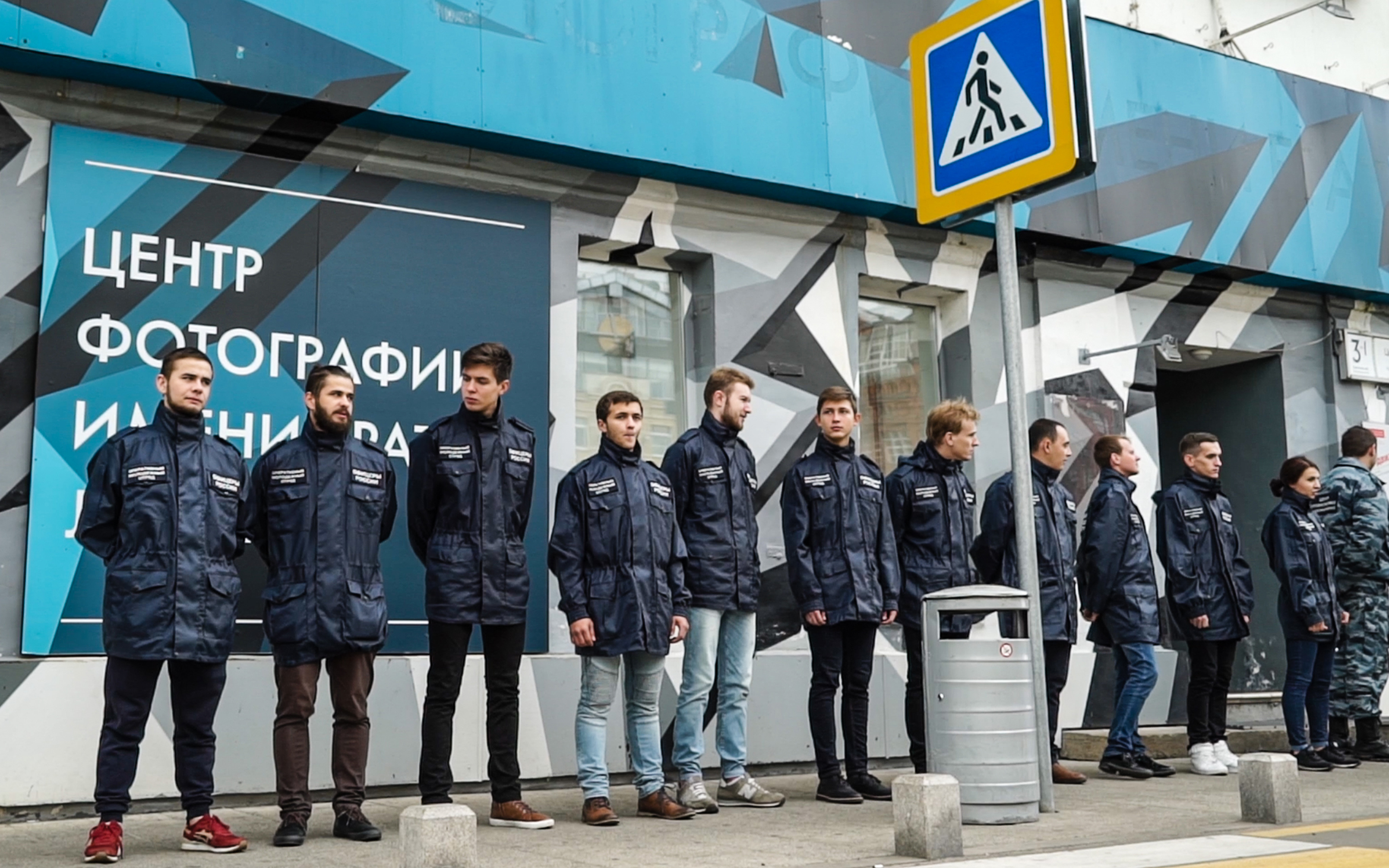 Some 20 activists in matching uniform jackets and camouflage from a little-known non-governmental organization called "Officers of Russia" stand outside the doors of the Lumiere Brothers Gallery close to the Kremlin in Moscow on September 25, 2016. Pro-Kremlin activists threw urine on pictures by a controversial US photographer at a Moscow gallery and forced the show's closure after a government adviser condemned the images as "child pornography." The exhibition showed pictures by Jock Sturges, a well-known photographer whose nude images of children have regularly prompted accusations of pedophilia, which he denies. Courtesy of Andrei Borodulin/AFP/Getty Images.