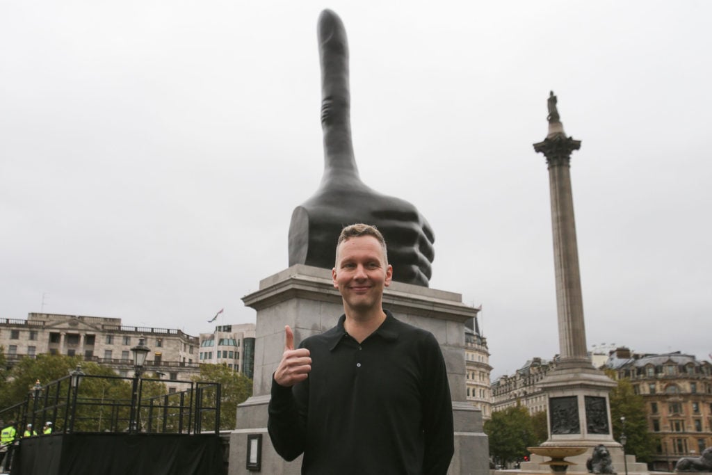 British artist David Shrigley poses for a photograph in front of his new Fourth Plinth sculpture, <em>Really Good</em>, after its unveiling in Trafalgar Square in central London on September 29, 2016. Courtesy of Daniel Leal-Olivas/AFP/Getty Images.
