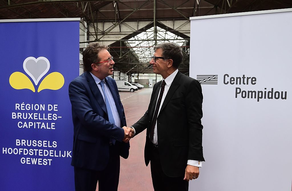 Pompidou Center President Serge Lasvignes (right) and Brussels region President Rudi Vervoordt shake hands as they unveil a project to transform a former Citroen car garage in Brussels into a museum for modern and contemporary art, at the on September 29, 2016. Photo Emmanuel Dunand/AFP/Getty Images.