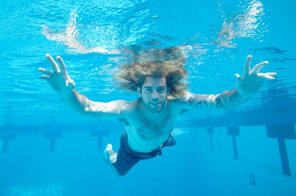 Spencer Elden recreates his pose from the cover of Nirvana's album Nevermind, which he shot 25 years later as a baby.  Courtesy John Chapple.