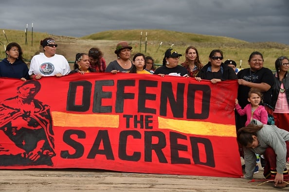 Native Americans march to a burial ground sacred site that was disturbed by bulldozers building the Dakota Access Pipeline (DAPL), near the encampment where hundreds of people have gathered to join the Standing Rock Sioux Tribe's protest of the oil pipeline that is slated to cross the Missouri River nearby, September 4, 2016 near Cannon Ball, North Dakota. Photo Robyn Beck/AFP/Getty Images.