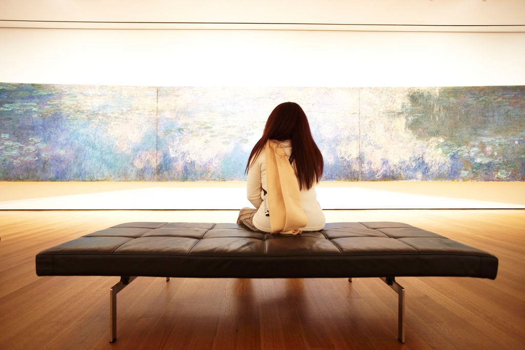 A visitor to New York's Museum of Modern Art takes in Claude Monet's Reflections of Clouds on the Water-Lily Pond. Courtesy of Jason Brownrigg/the Museum of Modern Art.
