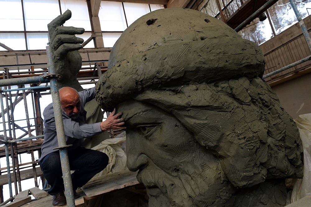 A picture taken on June 2, 2015 shows Russian sculptor Salavat Shcherbakov looking at a model for a monument to Vladimir the Great at his workshop in Moscow. Courtesy of Vasily Maximov/AFP/Getty Images.