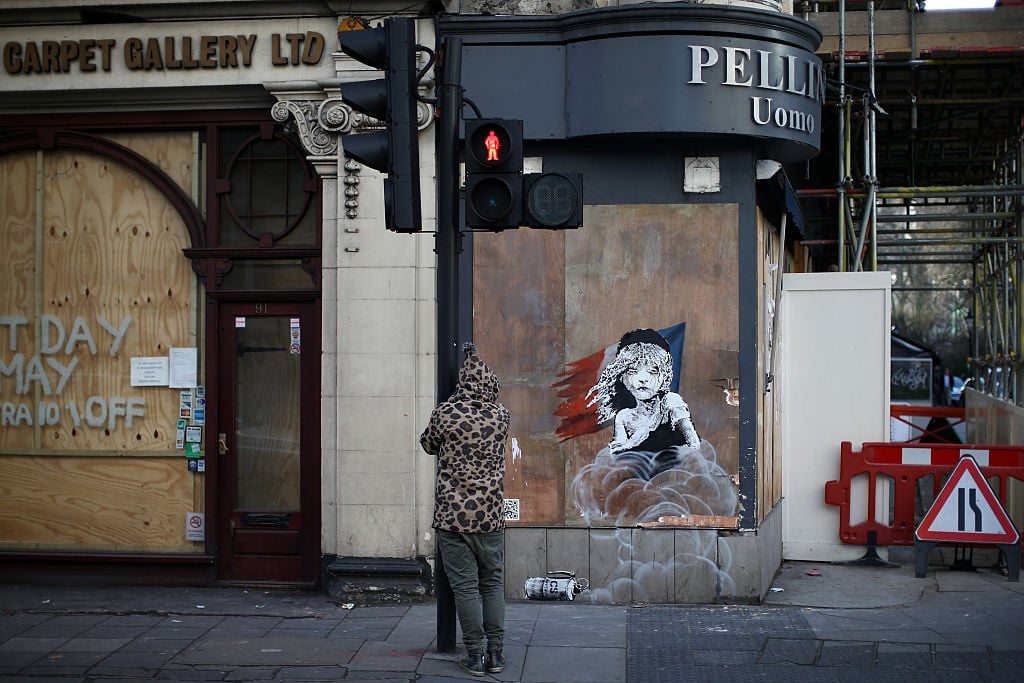 Banksyn toistuva naisten käyttö taiteessaan on saanut jotkut uskomaan, että taiteilija on todellisuudessa nainen. Kuva: Carl Court / Getty Images.'s repeated use of females in his art has lead some to believe the artist is in fact a woman. Photo: Carl Court/Getty Images.