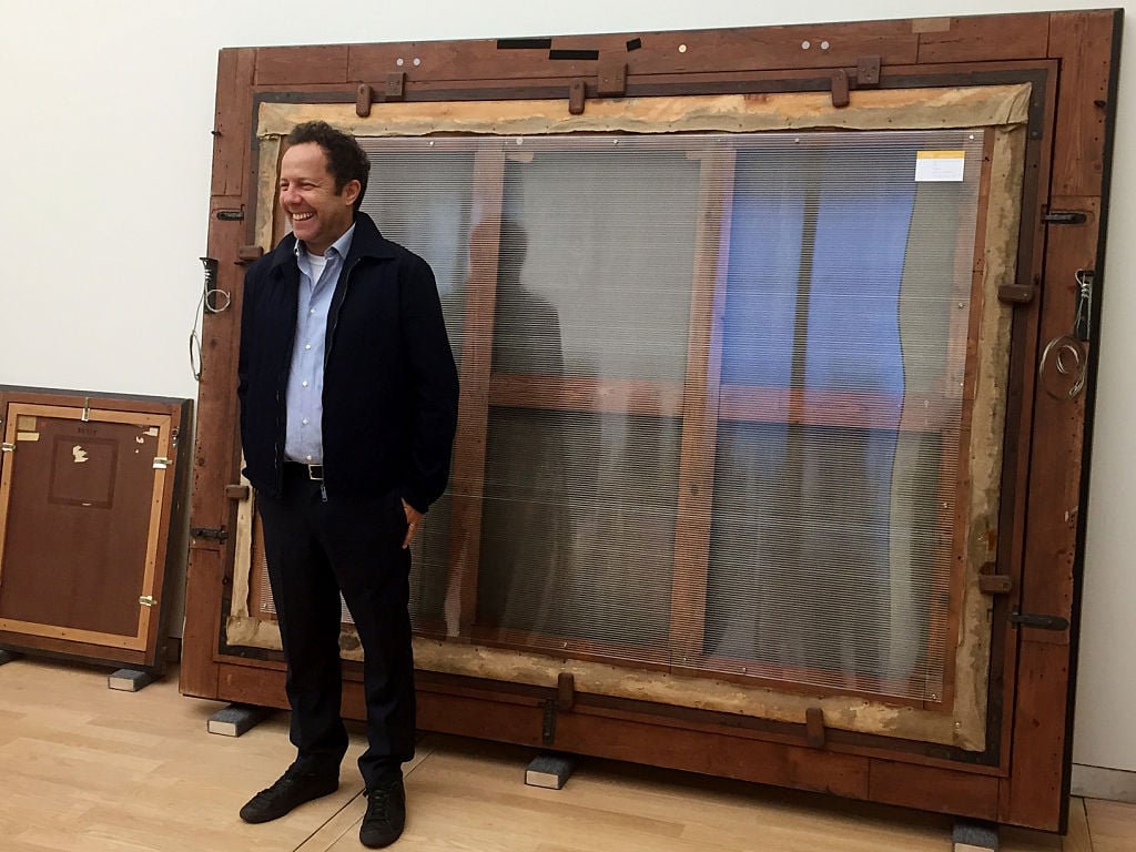 Brazilian artist Vik Muniz stands in front of his reproduction of the back of Rembrandts painting The Anatomy Lesson of Dr Nicolaes Tulp in The Hague on June 7, 2016. Courtesy of JO BIDDLE/AFP/Getty Images.