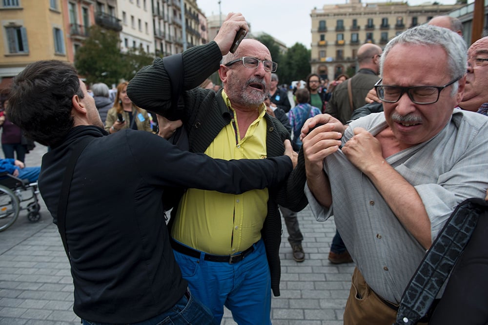A man is held back as he tries to hit another during the installation of a temporary exhibit titled "Franco, Victory, Republic, Impunity and Urban Space." Courtesy of Josep Lego/AFP/Getty Images.