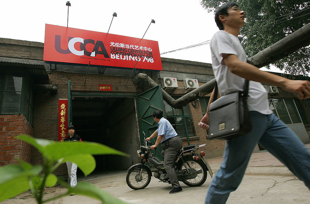 Pedestrians walk past the construction site of the Ullens Center for Contemporary Art (UCCA), 19 June 2007 in Beijing, Courtesy of FREDERIC J. BROWN/AFP/Getty Images.