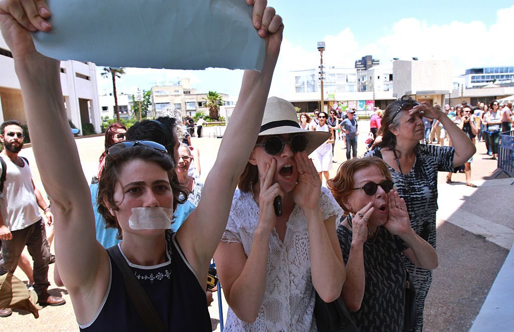 Israeli artists shout slogans as they take part in a protest against Minister of Sports and Culture Miri Regev (unseen) upon her arrival to a theatre awards ceremony in Tel Aviv, on June 19, 2015. Courtesy of GIL COHEN MAGEN/AFP/Getty Images.