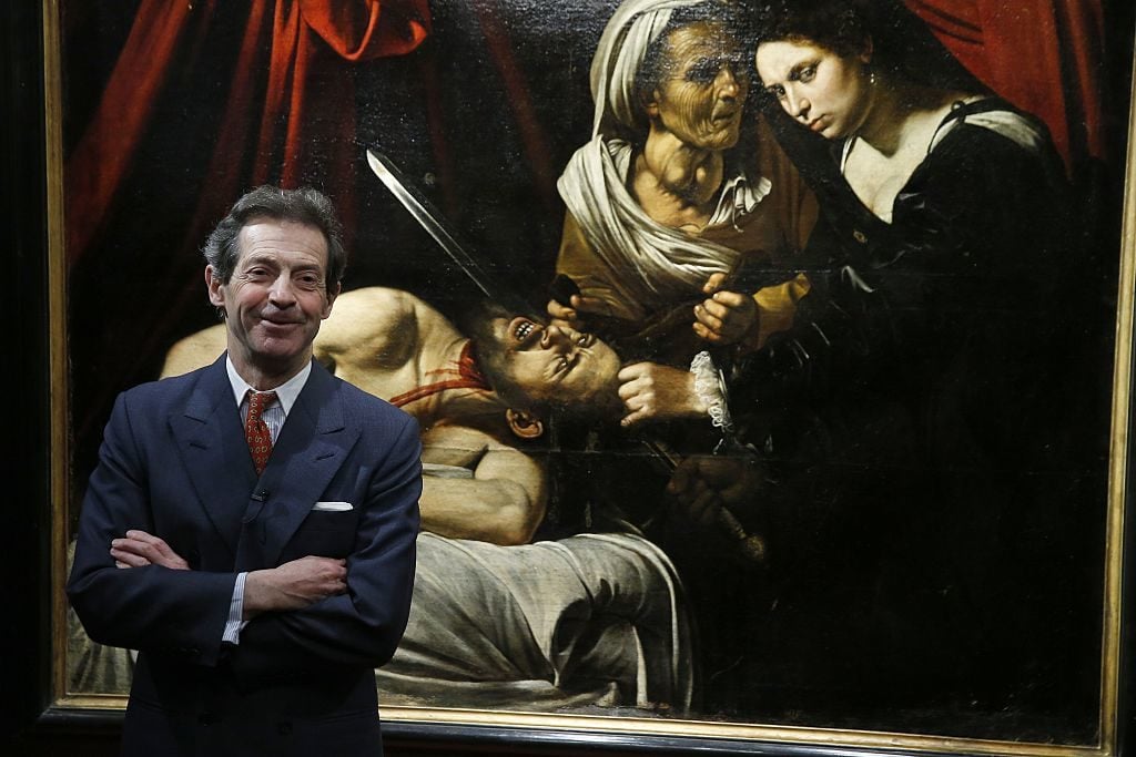 French painting expert Eric Turquin poses on April 12, 2016 in Paris with Judith cutting off the head of Holofernes, presented as being painted by Italian artist Caravaggio (1571-1610), while experts are still to determine its authenticity. Photo courtesy Patrick Kovarik/AFP/Getty Images.