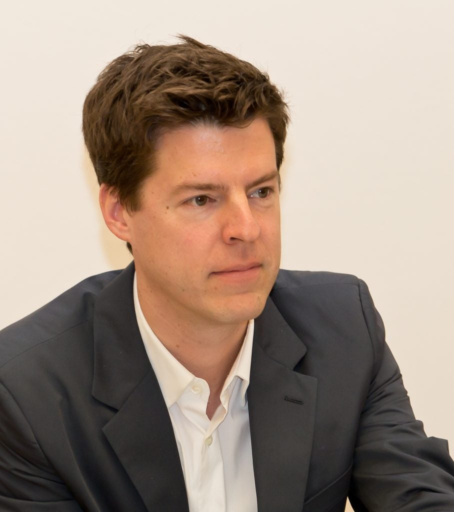 Philipp Kaiser. A young white man with brown hair wearing a white collared shirt and a dark suit jacket.