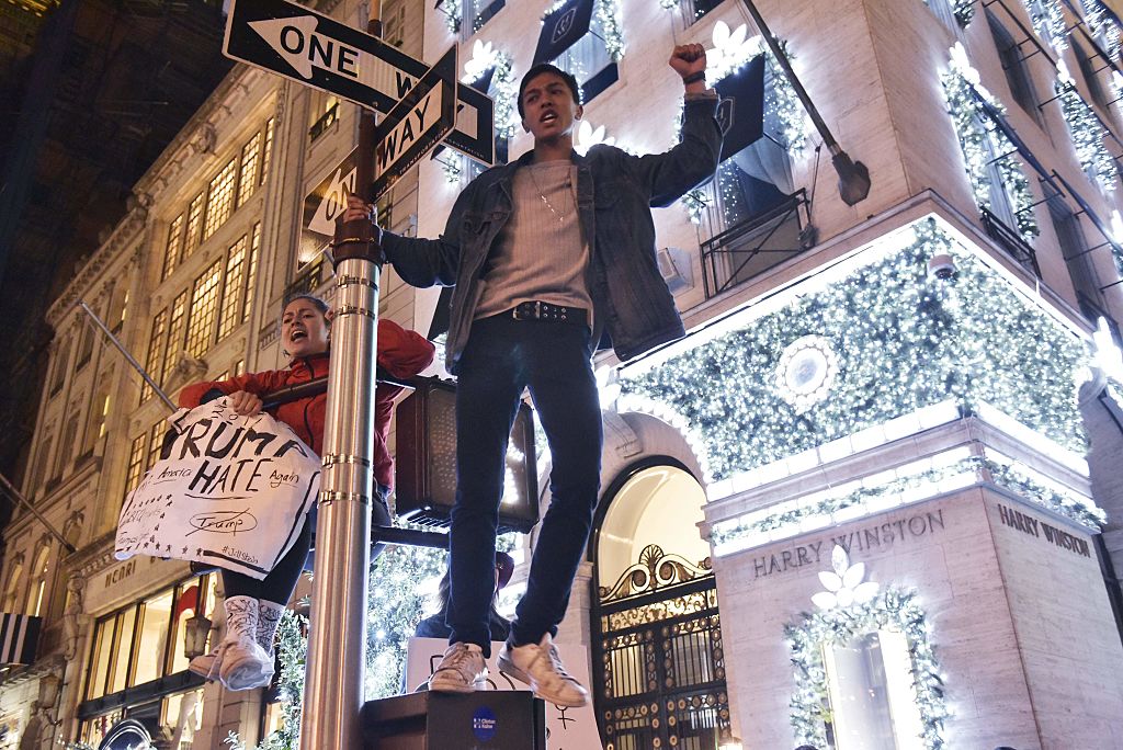 Protestors on a signpost shout slogans during a demonstration on 5th Avenue near Trump Tower on November 9, 2016 in New York, after Donald Trump was elected as the next president of the US. Photo Mandel Nigan/AFP/Getty Images.