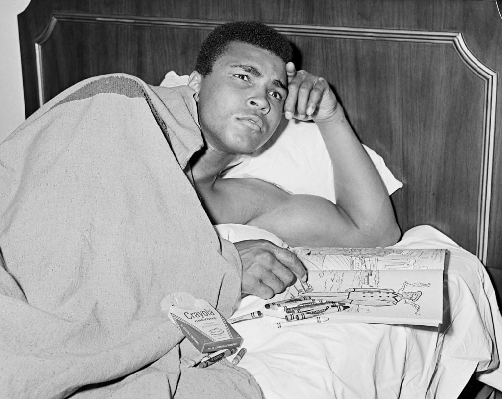George Kalinsky,Muhammad Ali with a coloring book of military officers (1967). Courtesy George Kalinsky. This was a time of soul searching for Ali who was contemplating his response to a draft notice from the United States Army.