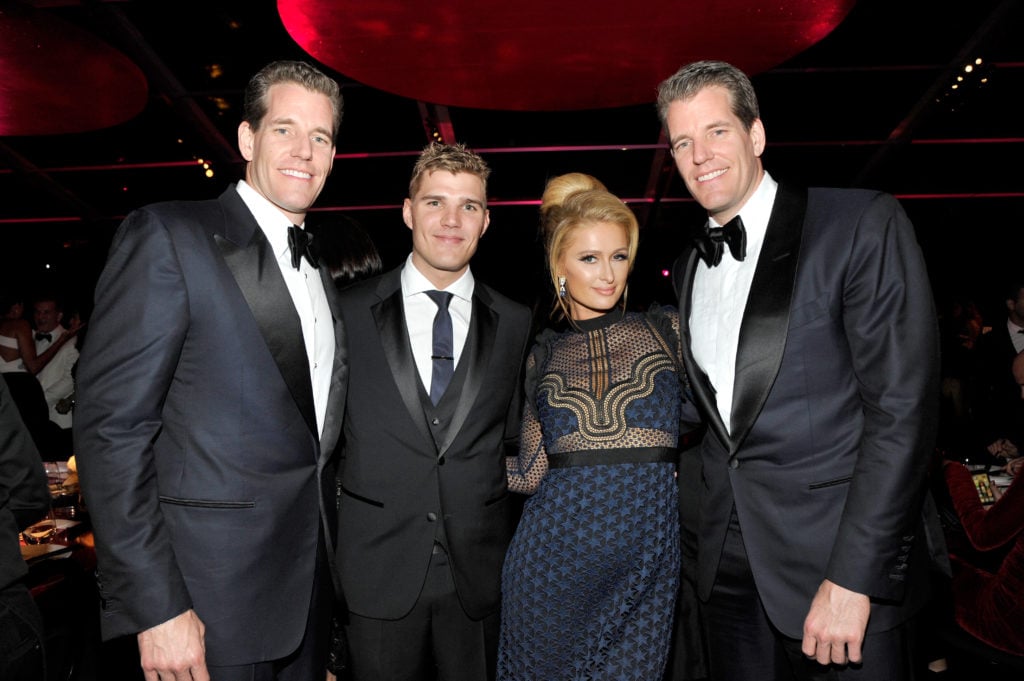Tyler Winklevoss, Chris Zylka, Paris Hilton, and Cameron Winklevoss at the MOCA Gala 2017 honoring Jeff Koons at the Geffen Contemporary at MOCA on April 29, 2017 in Los Angeles, California. Courtesy of John Sciulli/Getty Images for MOCA.