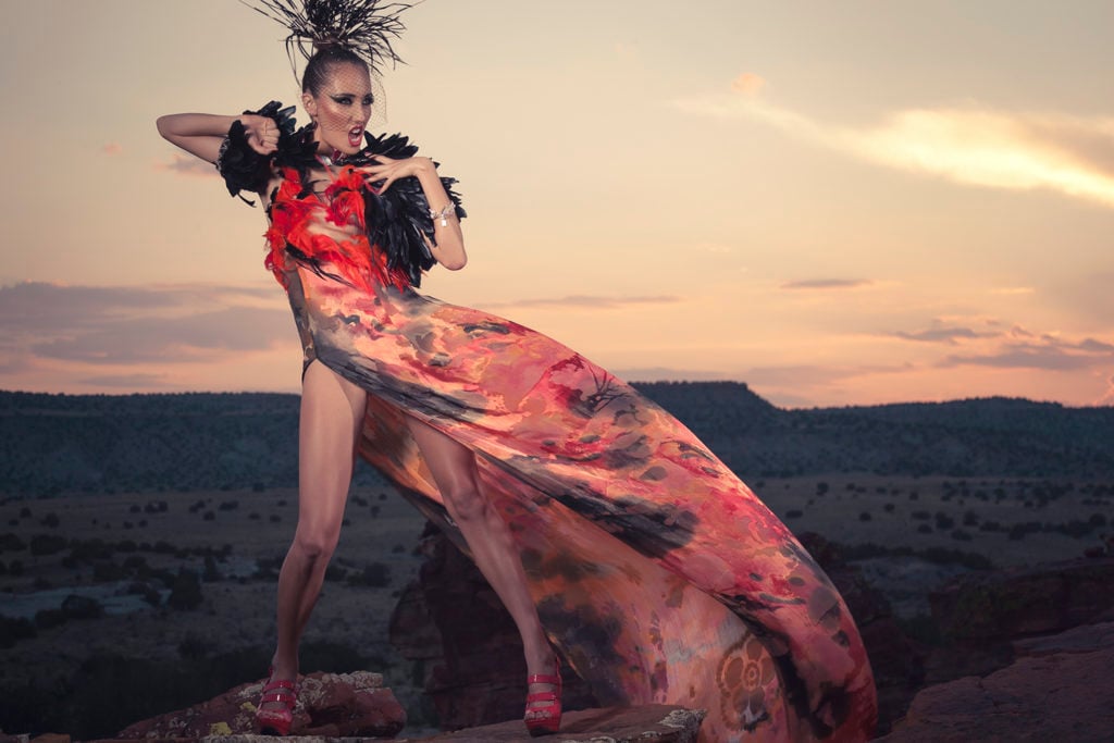 Orlando Dugi (Diné [Navajo]). Cape and dress from “Desert Heat” Collection, 2012 Silk, organza, feathers, beads, and 24-karat gold; feathers, beads, and silver. Photo by Nate Francis/Unék Photography. Hair and Makeup: Dina DeVore. Model: Mona Bear.