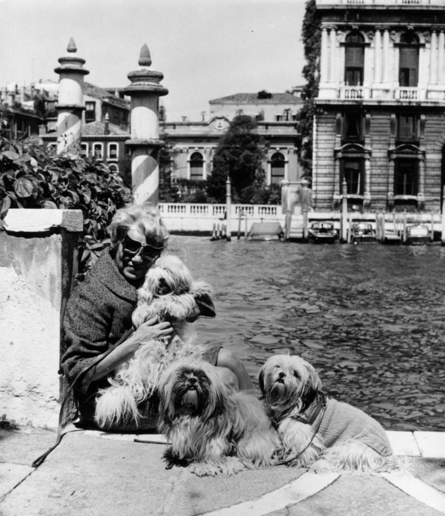 American art collector and millionairess Peggy Guggenheim with her pet dogs outside her eighteenth century Venetian palace on the Grand Canal in 1968. Courtesy of Keystone/Getty Images.