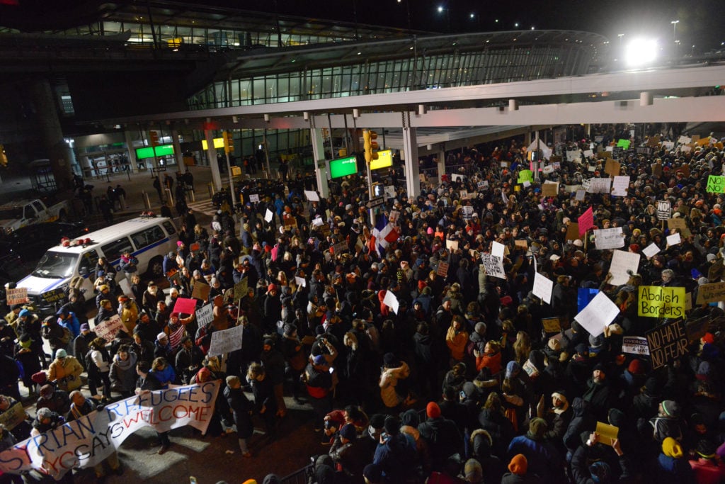 Protestors rally during a demonstration against the new immigration ban issued by President Donald Trump at John F. Kennedy International Airport on January 28, 2017 in New York City. President Trump signed the controversial executive order that halted refugees and residents from predominantly Muslim countries from entering the United States. Courtesy of Stephanie Keith/Getty Images.