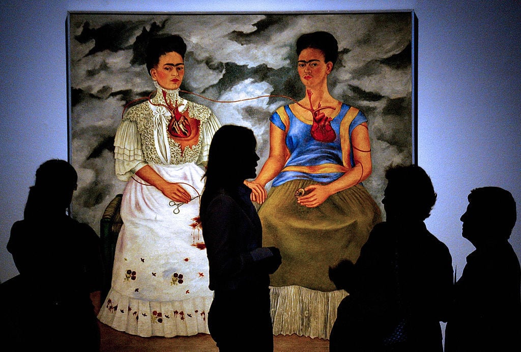 People look at the 1939 painting "Las Dos Fridas" (The Two Fridas), by Mexican artist Frida Kahlo. Courtesy of ALEJANDRO ACOSTA/AFP/Getty Images.