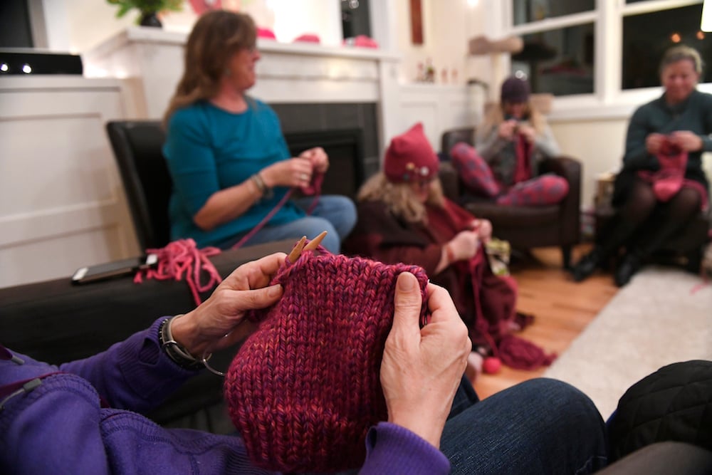 Ann Mitchell, just hands shown, puts the finishing touches on a pussyhat as, from left to right in the back Jen Grant, Julie Piller, and Debbie Asmus all help to knit dozens of pink hats at the home of Jen Grant on January 15, 2017 in Lafayette, Colorado. Photo by Helen H. Richardson/The Denver Post via Getty Images.